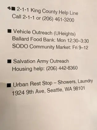 A printed list of help services: 2-1-1 King County Help Line, Vehicle Outreach (UHeights) at Ballard Food Bank and SODO Community Market, Salvation Army Outreach housing help, and Urban Rest Stop – Showers, Laundry.