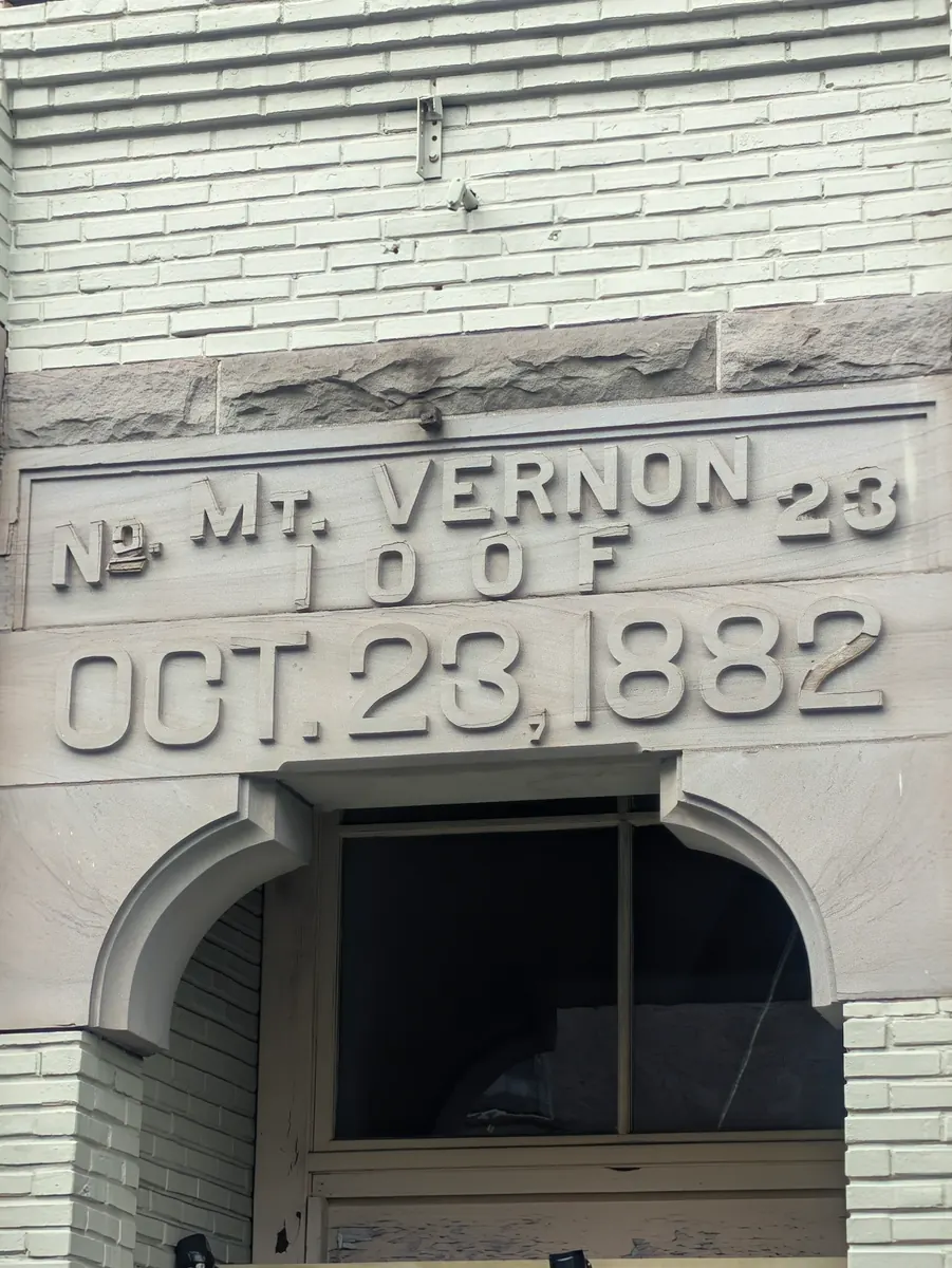 Lettering carved into the pale stone front of an old building, reading Mt. Vernon 23 I.O.O.F., October 23, 1882.
