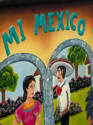 A hand-painted restaurant sign reading Mi Mexico, with a man in a wide white sombrero and a woman in a pink dress standing beneath stone arches.
