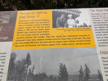 A yellow section of a roadside heritage panel headed Naming the Highway: King George VI, beside an archive photograph captioned King George VI and Queen Elizabeth at Port Mann, June 1939.