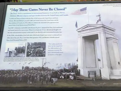 An interpretive panel headed May These Gates Never Be Closed, with a drawing of the Peace Arch and an archive photograph of the crowd at its dedication.