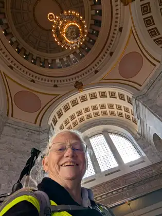 Jeana smiles up at the camera beneath the patterned dome and arches inside the Washington State Capitol.