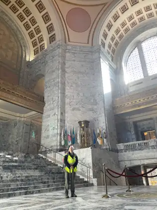 Jeana stands beside a marble staircase under the high ceiling of the Capitol rotunda.