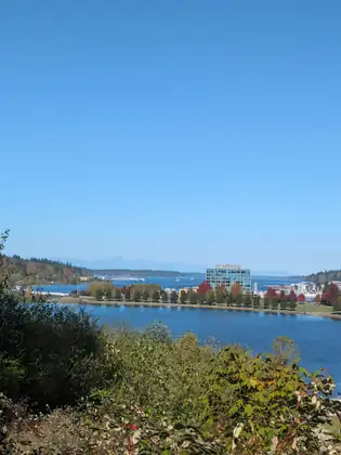 A view over the water toward the town and distant hills under a clear blue sky.